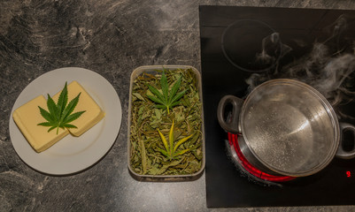 Obraz na płótnie Canvas Making of marijuana butter with leafs and yellow butter which will be green