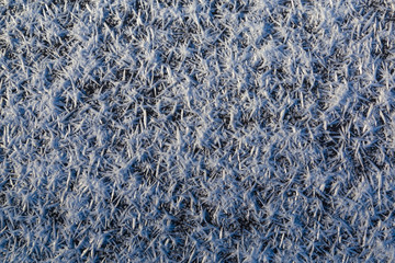 Beautiful macro crystals of white ice on dark icy surface