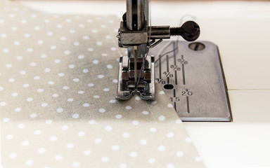 Sewing machine with fabric and thread on a whine background. Close up and copy space.