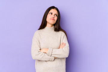 Fototapeta premium Young caucasian woman isolated on purple background tired of a repetitive task.
