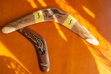 Two old boomerangs laying on the wooden glossy table. Souvenirs from Australia on display, shallow...