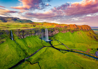 View from flying drone. Captivating summer view of Seljalandsfoss waterfall. Colorful sunrise in Iceland, Europe. Beauty of nature concept background.