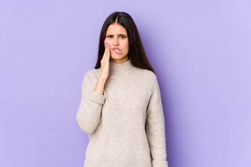 Young caucasian woman isolated on purple background having a strong teeth pain, molar ache.