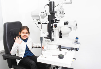 Little girl patient in ophthalmologist's office. Girl is not afraid to check eyesight in a medical clinic