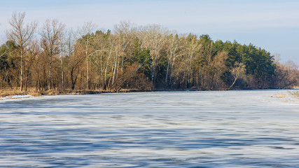 Ice covered river and forest on a sunny day. Web banner.