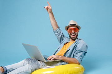 Traveler tourist man in yellow clothes glasses isolated on blue background. Passenger traveling...