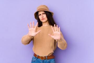 Young caucasian woman isolated on purple background rejecting someone showing a gesture of disgust.