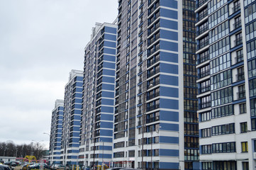 Obraz premium New modern tall blue glass multi-storey comfortable urban monolithic frame houses buildings skyscrapers new buildings in the big city of the megalopolis