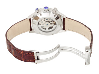 wristwatch back view internal mechanism with gears behind the glass cover of the iron case and open lock on leather strap, closeup.