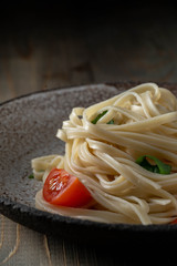 coocked egg noodles with tomatoes and basil