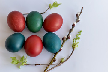 Easter eggs of different colors and willow branches.