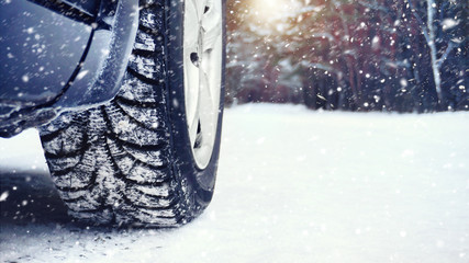 Wheel of a car on a winter road in a blizzard