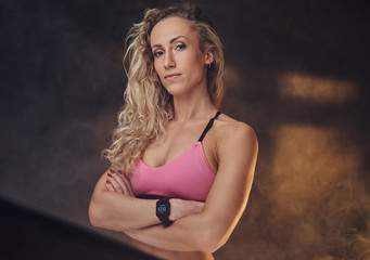 Fototapeta na wymiar Attractive blond woman in sporty pink top is posing for photographer.