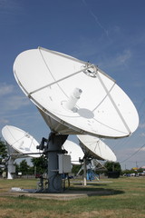 Satellite dishes against blue sky