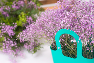 blue basket with pink gypsophila flower close up.