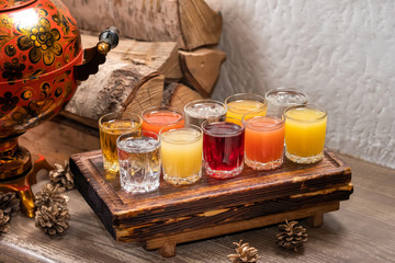 Colourful set of alcoholic cocktails in shot glasses shooters on wooden table for an alcoholic party. Set of wine, brandy, liquor, tincture, cognac, whiskey background, toast concept.