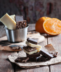 white and black chocolate on a wooden table with orange and knife