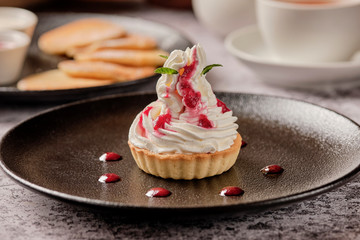 Cupcakes with whipped white vanila cream with a cup of black coffee americano for breakfast, background with copyspace. Food and drink concept.