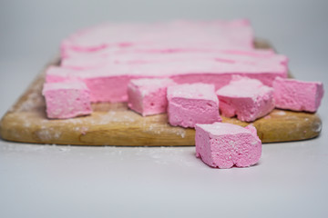 Pink marshmallows on a cutting board