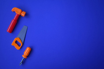 .Construction tools on a blue background. Screwdriver, hammer. Kids toys.