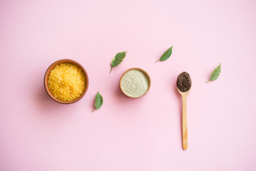 Cosmetic bath salt, grape gomaj for the face, coffee scrub for the body on a pink background.