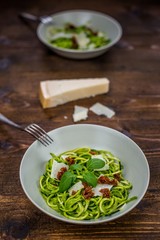 zucchini spaghetti on a dark table with cheese