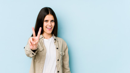 Young caucasian woman isolated on blue background showing number two with fingers.