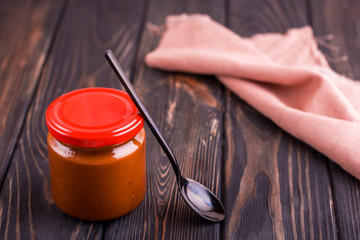 Homemade salted caramel on a dark table with a beautiful black spoon and milk.
