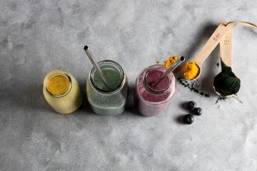 Obraz na płótnie Canvas superfood powders and smoothie with natural nutrients curcuma, spirulona and yam 
