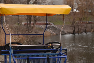 blue trishaw in the winter on a background of a pond