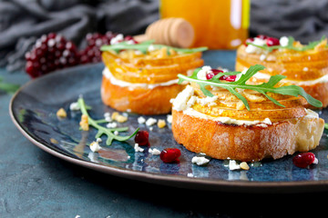 Crostini with pear, feta cheese, honey, nuts and pomegranate. Top view with copy space.