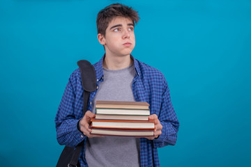 teen student boy with backpack and books isolated on color background