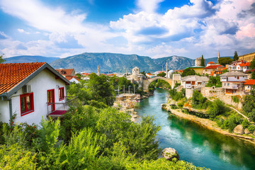 Fototapeta na wymiar Fantastic Skyline of Mostar with the Mostar Bridge, houses and minarets, during sunny day.