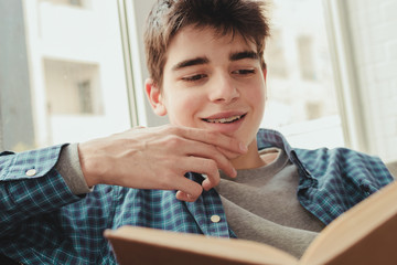 Fototapeta na wymiar young teenage boy reading or studying at home