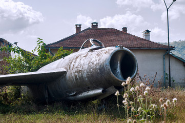 Old neglected Soviet Russian aircraft jet fighter MIG-15 on countryside village meadow
