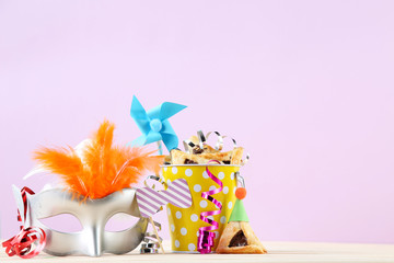 Purim holiday composition. Cookies with party with bucket and supplies on pink background