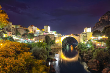 Majestic evening view of Mostar with the Mostar Bridge, houses and minarets, at evening