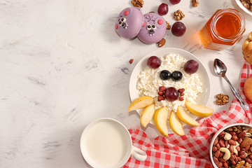 Healthy breakfast, fun food for children. The concept of healthy and natural food. Cottage cheese with granola or granola, grapes, nuts and croissants, top view, selective focus.
