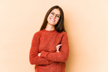 Fototapeta premium Young caucasian woman isolated on beige background who feels confident, crossing arms with determination.