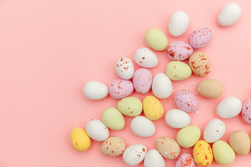 Fototapeta na wymiar Happy Easter concept. Easter candy chocolate eggs and jellybean sweets isolated on trendy pastel pink background. Simple minimalism flat lay top view copy space