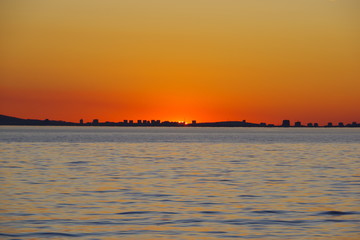 A romantic sunset against the background of the orange sky and fantastic glimpses of the reflecting...