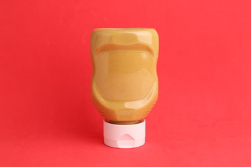 pot of mustard sauce in color background