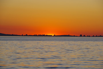 A romantic sunset against the background of the orange sky and fantastic glimpses of the reflecting sun in the bluish-gray water. An evening that is impossible to forget.
