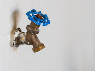 Outdoor water spigot for watering garden and lawn irrigation. Classic brass water faucet with blue...