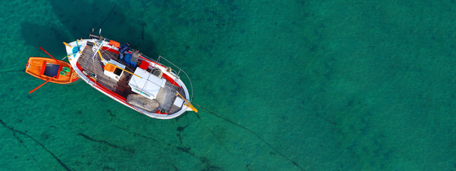 Fototapeta na wymiar Aerial drone ultra wide photo of traditional fishing boat docked in old port of Mykonos island, Cyclades, Greece