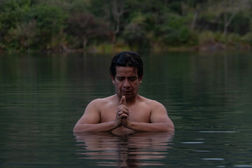 Man meditate in middle of a lake. 