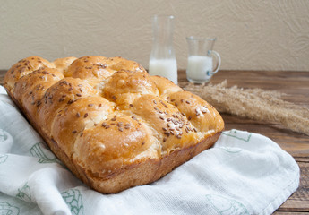 freshly baked buns with sesame seeds and milk