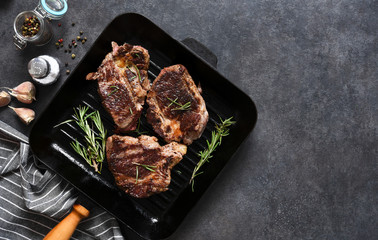 The process of cooking beef steak in a grill pan with spices. Grilled meat. View from above.
