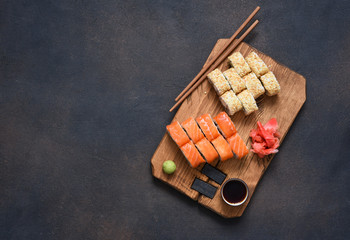 Different types of sushi served on a wooden board. Sushi menu. Japanese food.