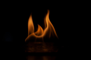 Fiery background. Flames of fire in the dark. Flame texture. Tongues of fire rise smoothly. A...